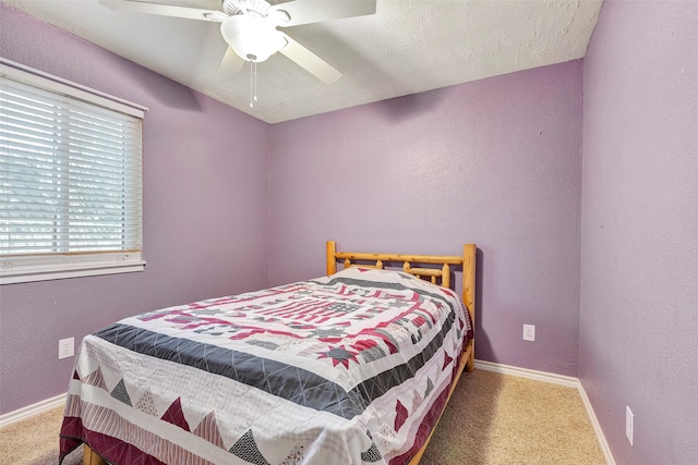 carpeted bedroom with ceiling fan and a textured ceiling