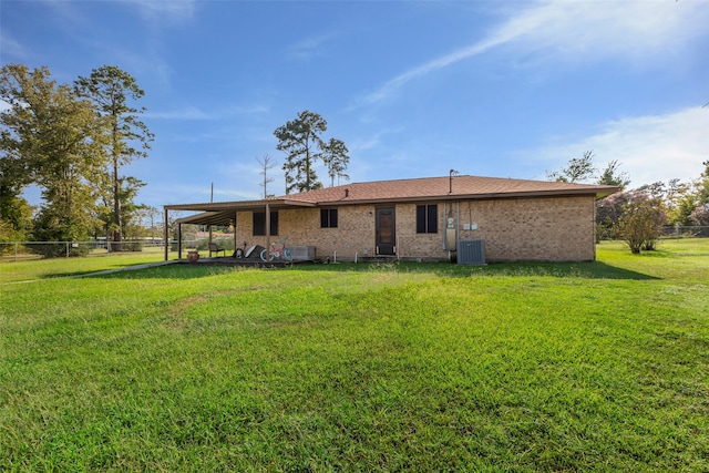 rear view of house featuring a lawn and central air condition unit