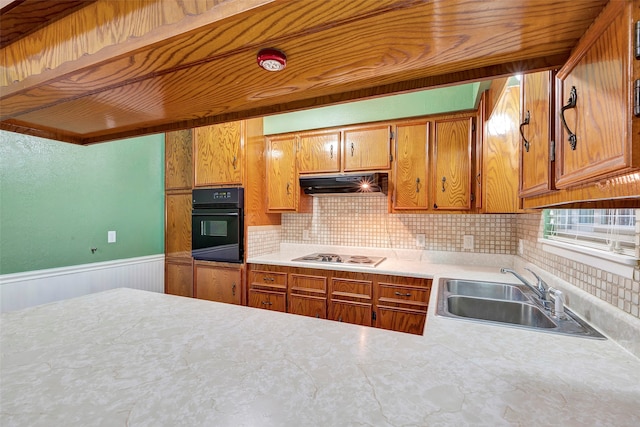 kitchen with white gas stovetop, backsplash, oven, and sink