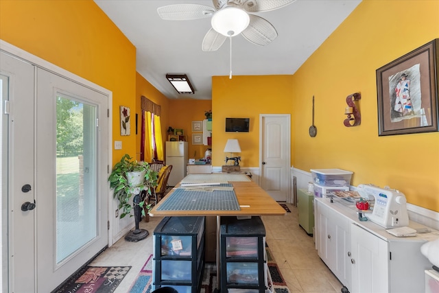 kitchen featuring white cabinets, light tile patterned floors, kitchen peninsula, ceiling fan, and white fridge