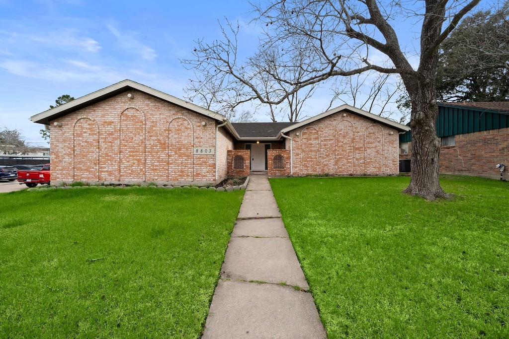 view of front of property featuring brick siding and a front lawn