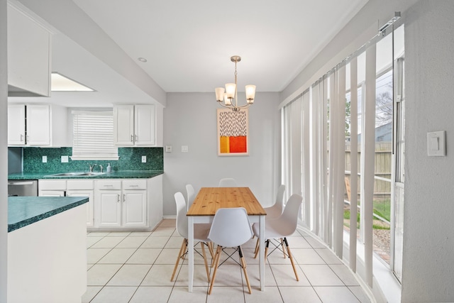 dining area with light tile patterned floors, baseboards, and a chandelier