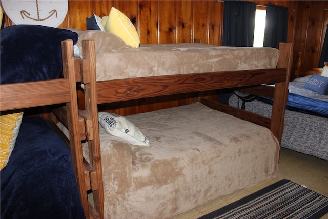 tiled bedroom featuring wood walls