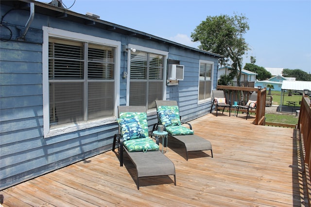 wooden deck featuring a wall unit AC