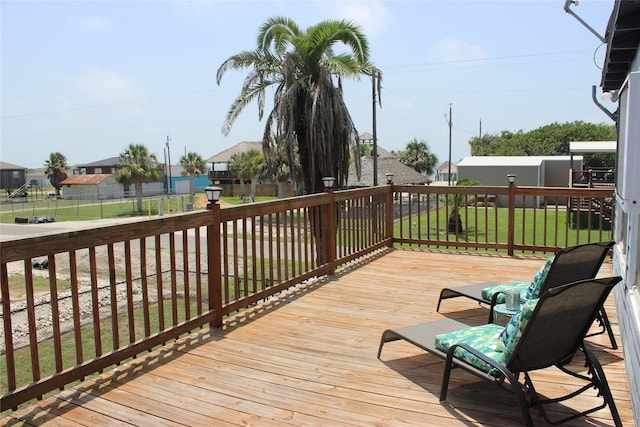 wooden deck featuring a lawn