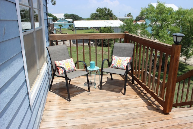 wooden deck featuring a lawn