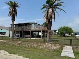 rear view of property with a lawn and a wooden deck