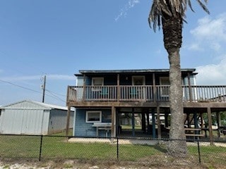 back of property with a storage unit and a deck