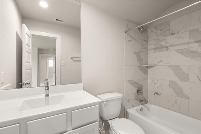 full bathroom featuring tiled shower / bath, toilet, and vanity