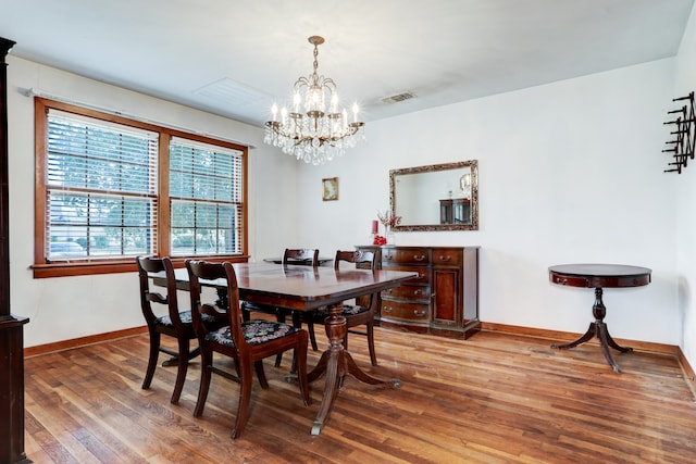 dining area featuring an inviting chandelier and hardwood / wood-style floors