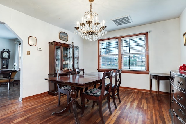 dining space featuring dark wood-type flooring and a chandelier