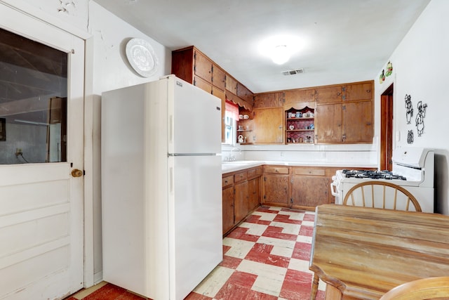 kitchen with sink, light tile patterned flooring, and white appliances