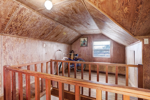 additional living space featuring wood-type flooring, wooden walls, lofted ceiling, and wooden ceiling