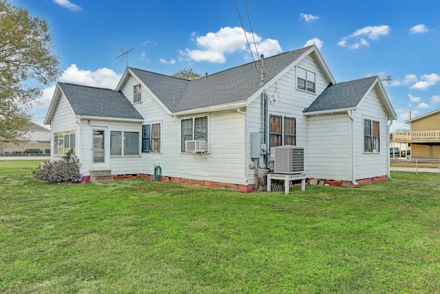 back of house featuring cooling unit, central AC unit, and a yard