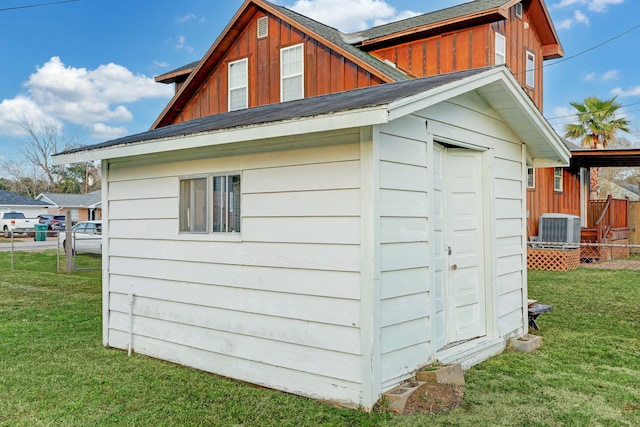 view of outdoor structure with central air condition unit and a yard