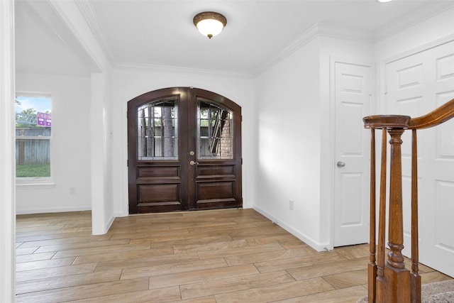 entryway with arched walkways, french doors, light wood-type flooring, and crown molding