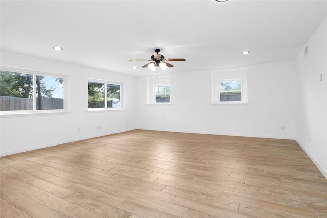 empty room with recessed lighting, visible vents, light wood-style floors, a ceiling fan, and baseboards