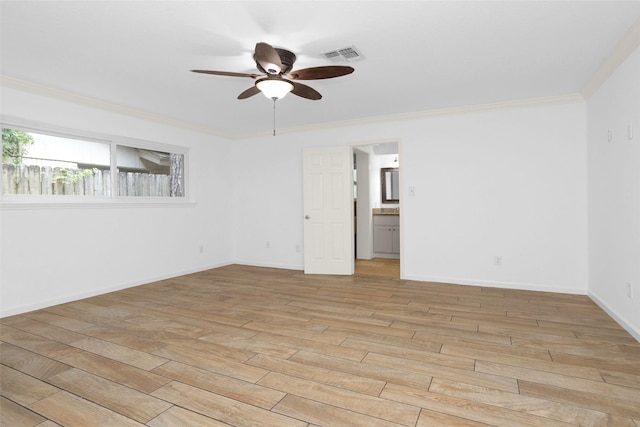 spare room featuring light wood finished floors, baseboards, visible vents, a ceiling fan, and ornamental molding