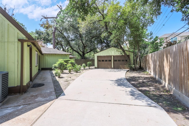 exterior space featuring an outbuilding, fence, and a detached garage