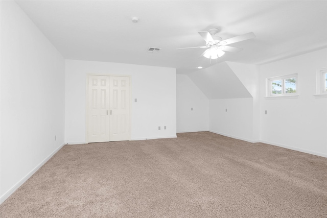 additional living space featuring visible vents, baseboards, lofted ceiling, ceiling fan, and carpet