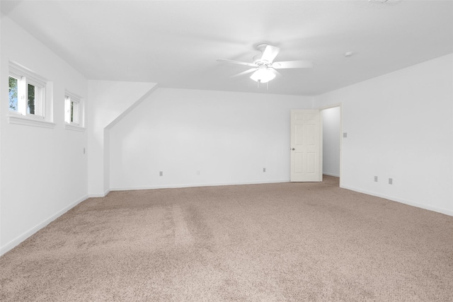 carpeted empty room featuring a ceiling fan and baseboards