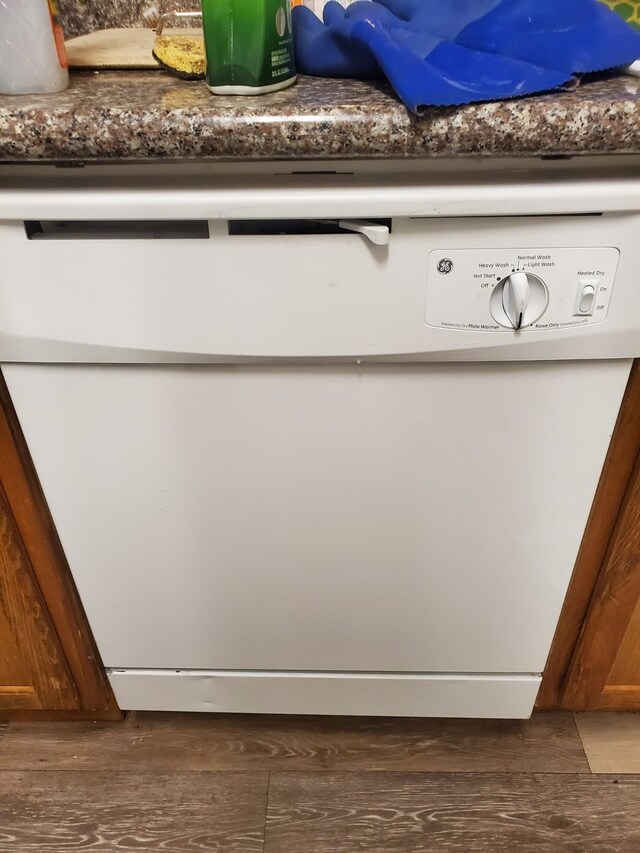 room details featuring dark wood-type flooring and white dishwasher