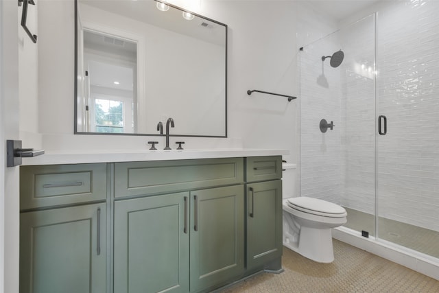 bathroom featuring a shower with shower door, vanity, toilet, and tile patterned flooring