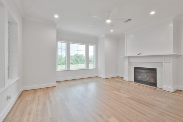 unfurnished living room featuring ornamental molding, ceiling fan, and light hardwood / wood-style floors