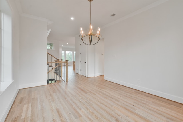 unfurnished dining area featuring light hardwood / wood-style flooring, a chandelier, and crown molding