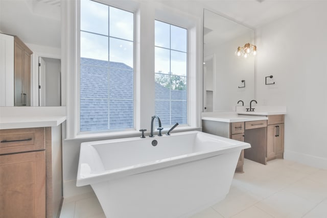 bathroom featuring a bathing tub, vanity, and tile patterned flooring