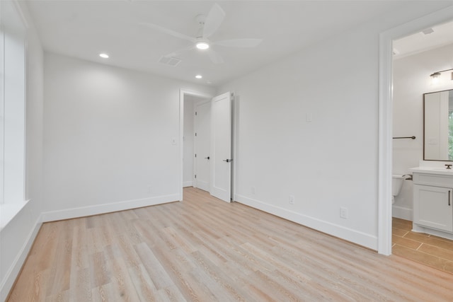 unfurnished bedroom with ceiling fan, light wood-type flooring, and ensuite bath