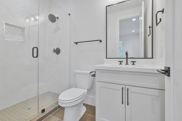 bathroom featuring an enclosed shower, vanity, tile patterned flooring, and toilet