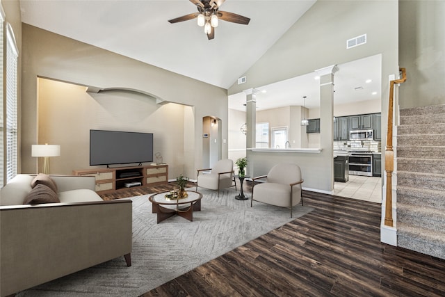 tiled living room featuring high vaulted ceiling, ceiling fan, and ornate columns