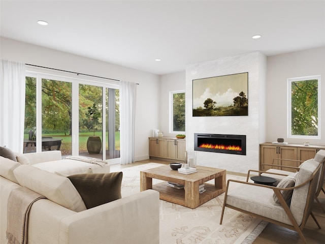 living room with a large fireplace and light wood-type flooring