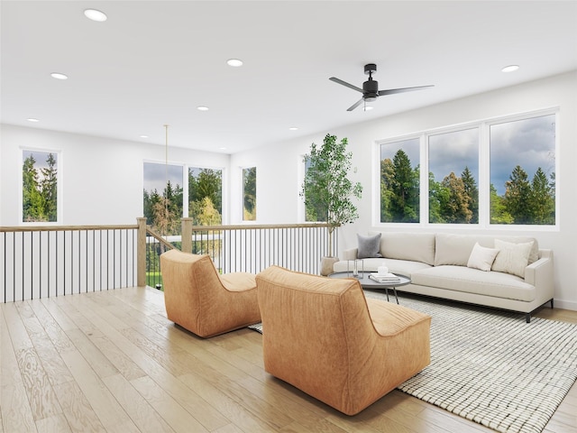 living room with ceiling fan and light hardwood / wood-style flooring