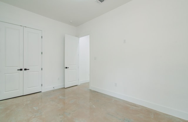 unfurnished bedroom with a closet and concrete floors