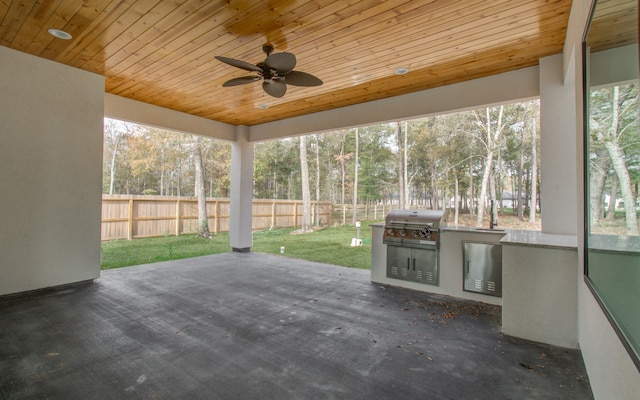 unfurnished sunroom featuring wood ceiling and ceiling fan