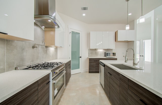 kitchen featuring appliances with stainless steel finishes, white cabinets, sink, decorative backsplash, and range hood