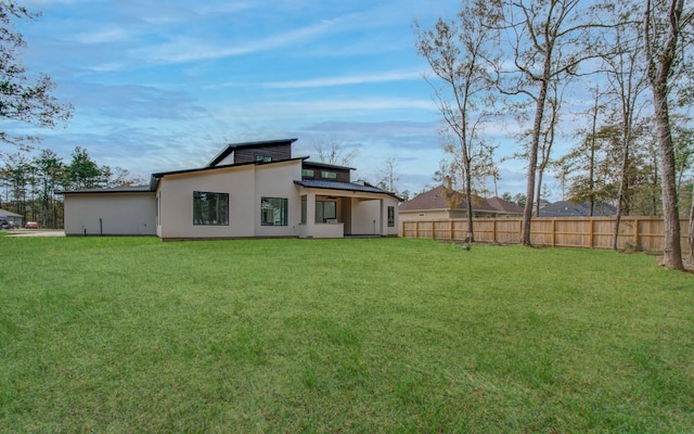 rear view of property with a lawn