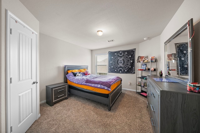 carpeted bedroom featuring a textured ceiling