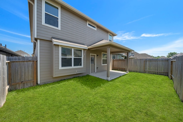 rear view of house featuring a patio and a yard