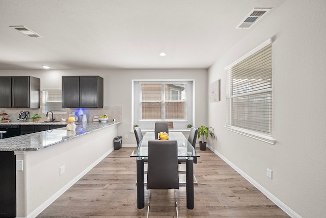 dining room with sink and light wood-type flooring