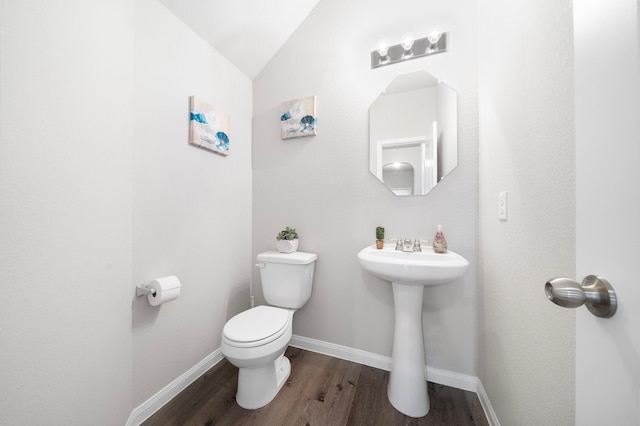 bathroom featuring toilet, vaulted ceiling, and hardwood / wood-style floors