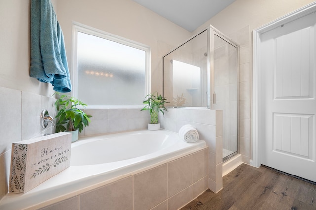 bathroom featuring shower with separate bathtub and wood-type flooring