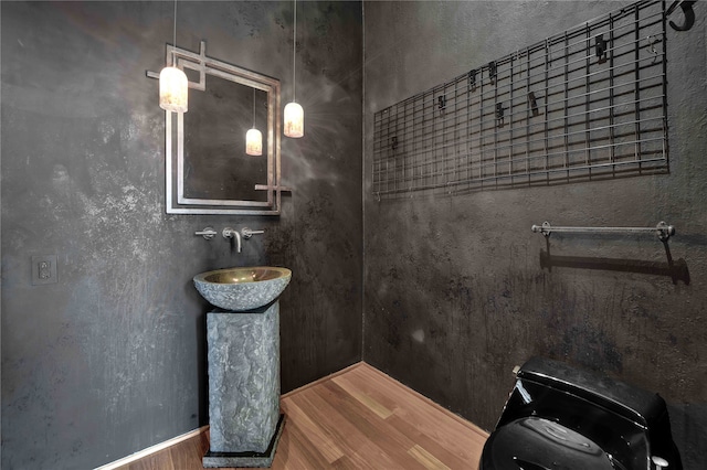 bathroom with toilet, hardwood / wood-style floors, and sink