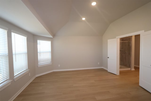 unfurnished bedroom with hardwood / wood-style floors and lofted ceiling