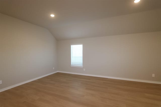 additional living space with lofted ceiling and light wood-type flooring