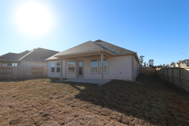 rear view of property with a yard and a patio area