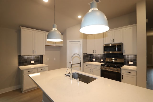 kitchen featuring pendant lighting, white cabinetry, stainless steel appliances, and sink