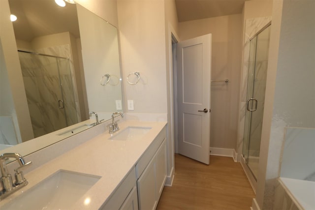 bathroom with walk in shower, wood-type flooring, and vanity